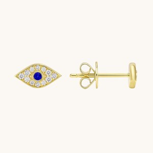 May include: A pair of gold-coloured stud earrings. Each earring features an eye-shaped design with a blue centre and surrounding white gemstones. The earrings have a post and butterfly backing.