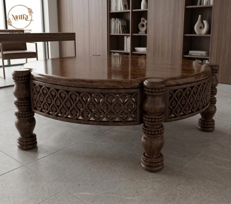 May include: A large, round wooden coffee table with a dark brown finish. The table features ornate carved detailing around the perimeter and is supported by four sturdy, turned legs. The tabletop has a polished, reflective surface.