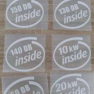 May include: Six white vinyl stickers with the text "150 DB inside", "130 DB inside", "140 DB inside", "10 kW inside", "160 DB inside", and "20 kW inside" in a stylized font. The stickers are on a clear backing.