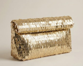 May include: A gold clutch bag with a rectangular shape and a fold-over flap. The bag is covered in small, rectangular gold sequins, creating a shimmering effect. The clutch is a stylish accessory.