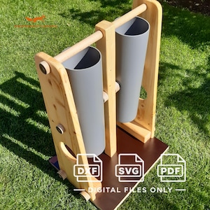 May include: A wooden stand featuring two vertical grey cylindrical tubes mounted between light-colored wooden side panels and a horizontal support bar. The base is a dark brown rectangular platform. Includes DXF, SVG, and PDF file icons.
