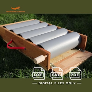Puede incluir: Un rodillo de arcilla de madera con cuatro cilindros grises montados en un marco rectangular. El dispositivo incluye un asa roja en el lateral, una base de madera clara y bisagras metálicas. El texto en la imagen dice DXF, SVG, PDF.