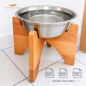 May include: A stainless steel pet bowl filled with water sits atop a wooden stand. The stand is made of light-colored wood and has a unique, angled design. The bowl is elevated, and the image includes the text "DIGITAL FILES ONLY".