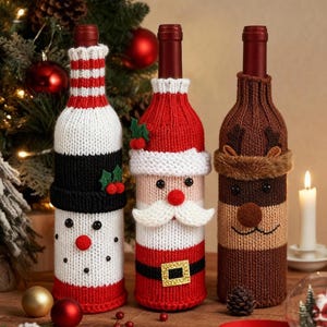 May include: Three festive wine bottle covers. One is a snowman, one is Santa Claus, and the third is a reindeer. The covers are knitted with red, white, black, and brown yarn. A lit candle and Christmas decorations are in the background.