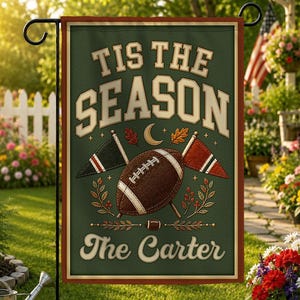 May include: A rectangular garden flag with a dark green textured background featuring the text 'TIS THE SEASON' in cream letters, a brown football, two small pennant flags, autumn leaves, and the personalized text 'The Carter' at the bottom.
