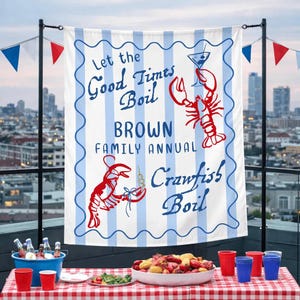May include: A white banner with blue stripes and text that reads "Let the Good Times Boil BROWN FAMILY ANNUAL Crawfish Boil." Red crawfish and a martini glass are illustrated. The banner is hanging above a table set for a crawfish boil.