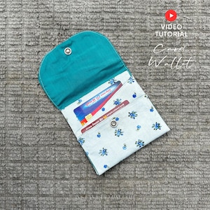 Puede incluir: Cartera de tarjetas abierta con interior turquesa y estampado floral en el exterior. La cartera está abierta, revelando tarjetas de crédito. El texto "Card Wallet" es visible en la esquina superior derecha.