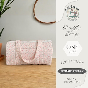 May include: A quilted duffel bag with a small pink floral pattern on a white background, featuring two handles and a top zipper. The text reads Stitchmora Sewing Patterns, Duffle Bag, One Size, PDF Pattern, Beginner Friendly, Instant Download.