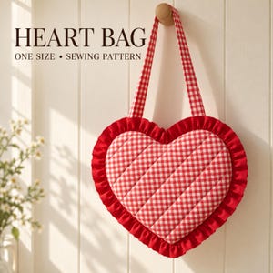 Puede incluir: Un bolso en forma de corazón con estampado de cuadros vichy rojo y blanco, costuras diagonales acolchadas y un borde de volantes rojo sólido. Incluye dos asas a juego y el texto HEART BAG ONE SIZE SEWING PATTERN.