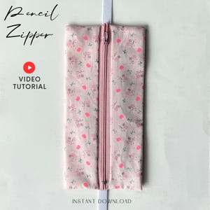 Op de afbeelding: Een roze etui met bloemenpatroon en bijpassende roze rits. De stof heeft een patroon van kleine roze hartjes en bloemen. Tekst op de afbeelding luidt "Pencil Zipper", "Video Tutorial" en "Instant Download".