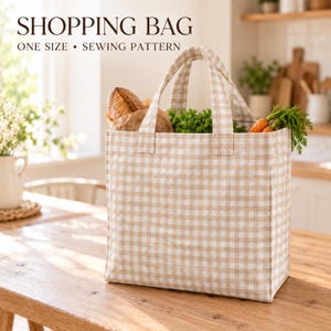 May include: A beige and white gingham shopping bag with two fabric handles. The bag is filled with a loaf of bread and fresh vegetables. Text at the top reads: SHOPPING BAG ONE SIZE • SEWING PATTERN. The bag has a square base and sides.