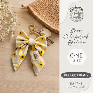 Puede incluir: Un soporte para bálsamo labial de tela color crema con forma de lazo y estampado de flores amarillas. Incluye un llavero de metal dorado y un pequeño bolsillo con un tubo de bálsamo labial blanco. El texto dice Stitchmora Sewing Patterns, Bow Chapstick Holder, ONE SIZE, BEGINNER FRIENDLY, INSTANT DOWNLOAD.