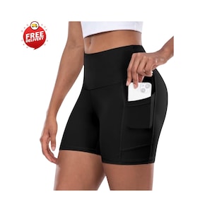 May include: Black athletic shorts with a high waistband and side pockets. A white smartphone is visible in one of the pockets. The shorts are designed for fitness activities.