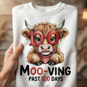 May include: White sweatshirt featuring a cartoon cow wearing red glasses and a bandana. The cow has the number "100" in red on its glasses. The text "Moo-ving Past 100 Days" is printed below the cow in black and red.