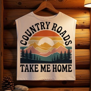 May include: White sleeveless t-shirt with a graphic design featuring the text "COUNTRY ROADS TAKE ME HOME" in black. The design includes a sunset, mountains, and pine trees in shades of orange, yellow, pink, and green.