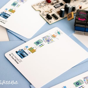 May include: A white card with a blue and green illustration of a computer circuit board. The text "From the desk of Ms. Grace Michael" is printed on the card.