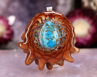 May include: A handcrafted pendant featuring a vibrant turquoise stone set within a detailed, brown, pinecone-shaped design. The pendant has a silver-colored bail and a unique, natural aesthetic. The turquoise stone is oval-shaped.