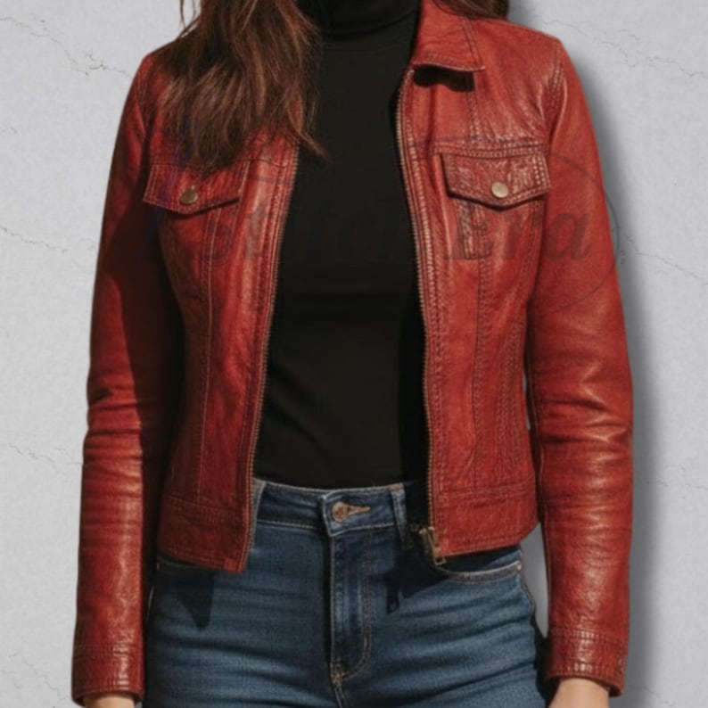 May include: A red leather jacket with a collared neckline, two chest pockets, and a zipper closure. The jacket has long sleeves and is worn over a black turtleneck and blue jeans.