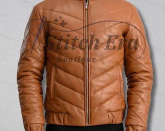 May include: A tan leather jacket with a quilted design. The jacket has a stand-up collar, a zipper closure, and two front pockets. The sleeves are long and have ribbed cuffs. The jacket is a medium size.