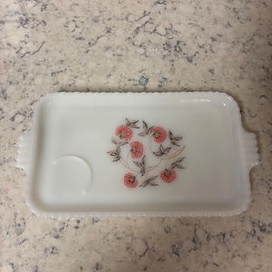 May include: A white ceramic mug with a black handle and the text "But First, Coffee" in a bold, black font. The mug is set against a neutral background, highlighting its simple design.