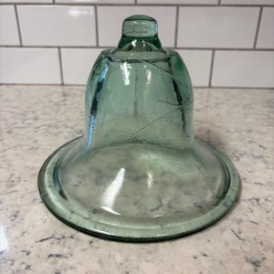 Antique French green glass cloche bell jar with flared base.