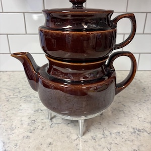Vintage USA stoneware brown drip coffee percolator pot with lid and metal legs.