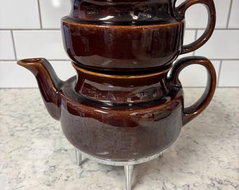 Vintage Amerikaanse steengoedbruine percolatorpot met deksel en metalen poten.