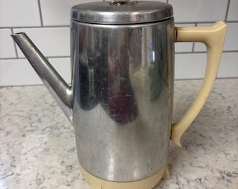 Cafetera eléctrica de aluminio de estilo vintage con perilla de vidrio y asas de plástico.