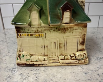 Vintage McCoy pottery "Cookie House" cookie jar with a green roof.