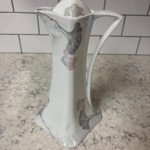 May include: A set of three ceramic nesting bowls in shades of blue, green, and white. The bowls feature a speckled glaze and a simple, modern design. The largest bowl measures approximately 6 inches in diameter.