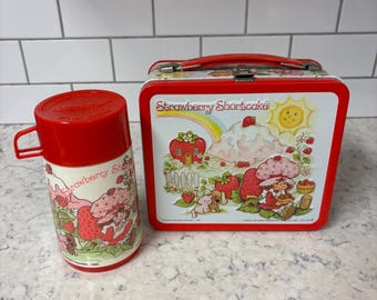 Vintage 1980 Strawberry Shortcake metal lunchbox and thermos set.