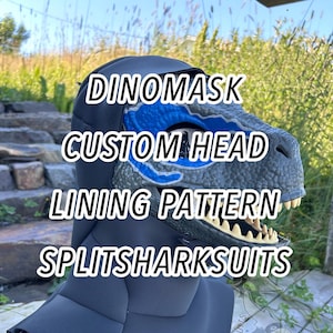 May include: A grey dinosaur mask with blue accents around the eye sockets and cream-coloured teeth. The mask features a black fabric hood covering the neck and head. Text on the image reads: DINOMASK CUSTOM HEAD LINING PATTERN SPLITSHARKSUITS.