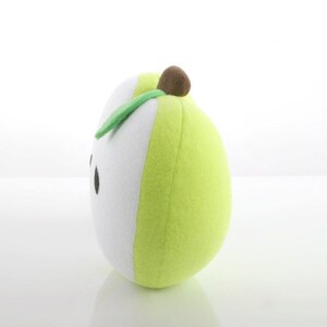 May include: A green and white plush pear with a brown stem and a green leaf. The pear has a simple black face.