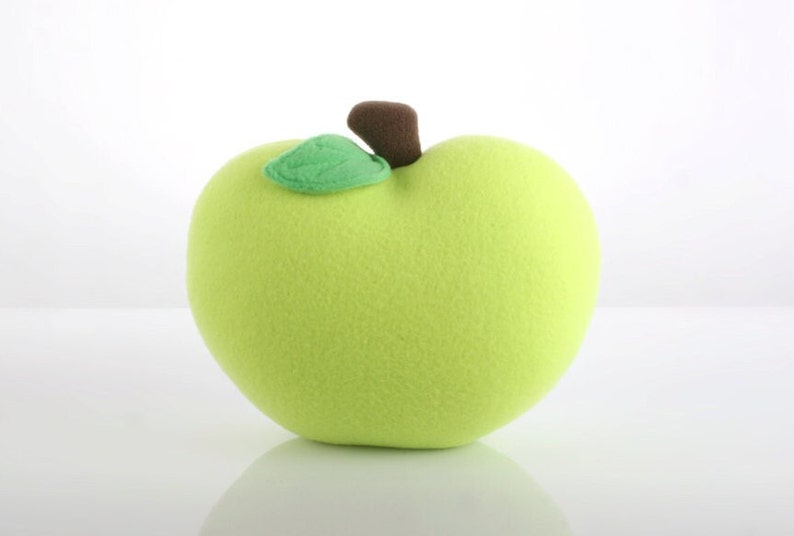 May include: A plush green apple with a brown stem and a green leaf.
