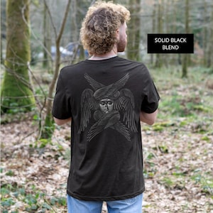 Puede incluir: Una camiseta negra de manga corta con un gráfico detallado en la espalda de un serafín con múltiples alas rodeando un rostro central. El texto SOLID BLACK BLEND aparece impreso en un recuadro negro en la esquina superior derecha.