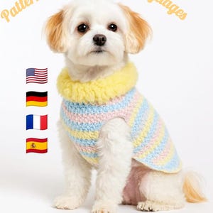 Puede incluir: Un perro blanco pequeño que lleva un suéter de ganchillo a rayas pastel con un cuello amarillo. La imagen incluye el texto "Pattern available in 4 languages" y "With free cat toy pattern."