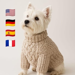 以下が含まれることがあります： ベージュのケーブルニットセーターを着た白い犬。画像には「Craft in Your Preferred Language」というテキストと、アメリカ、ドイツ、スペイン、フランスの国旗が含まれています。