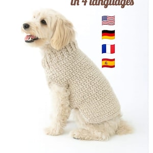 以下が含まれることがあります： ベージュのニットセーターを着た犬。画像には「4か国語で利用可能なパターン」というテキストと、米国、ドイツ、フランス、スペインの国旗が含まれています。