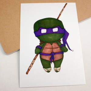 Op de afbeelding: Een cartoonillustratie van een Teenage Mutant Ninja Turtle met een paarse masker en bandana. De schildpad houdt een houten stok vast en draagt een bruine schild.