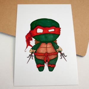 Op de afbeelding: Een cartoonillustratie van een Teenage Mutant Ninja Turtle die een rood bandana draagt en twee sai vasthoudt. De schildpad is groen met een bruine schild en is getekend in een chibi-stijl.