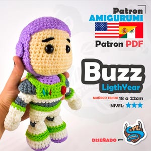 Puede incluir: Muñeco amigurumi de Buzz Lightyear hecho a mano, de aproximadamente 18 a 22 cm de altura, con casco morado, traje espacial verde y blanco y ojos negros. El muñeco está tejido y presenta el texto "Buzz Lightyear".