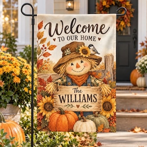 May include: A rectangular garden flag featuring a scarecrow wearing a hat with a sunflower and a small bird. The text reads Welcome TO OUR HOME and The WILLIAMS. The design includes autumn leaves, sunflowers, and orange, white, and green pumpkins.