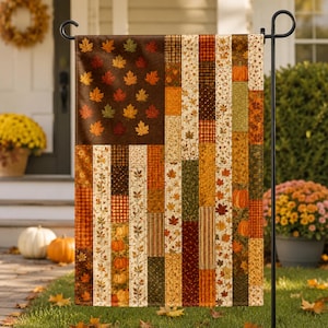 May include: A rectangular garden flag featuring a patchwork design that mimics the American flag. The canton displays brown fabric with scattered orange, yellow, and green maple leaves. The stripes consist of vertical panels with autumn motifs.