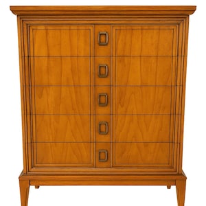 May include: A mid-century modern wooden chest of drawers with six drawers. The chest is a warm honey color with rectangular brass drawer pulls. The chest has a rectangular frame and tapered legs.
