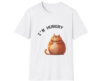 May include: White t-shirt featuring a cartoon illustration of a plump orange cat with the text "I'm Hungry". The cat has a green collar and a grumpy expression. The shirt is a classic crew neck style.