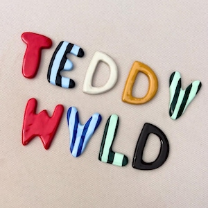 Puede incluir: Un juego de tres tazas de cerámica con un acabado mate moteado. Las tazas son de color crema, gris claro y gris oscuro. Cada taza tiene un diseño simple y minimalista.