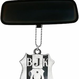 May include: A black rearview mirror with a silver emblem hanging from a chain. The emblem features the letters "BJK" and the number "1903" on a shield with a crescent moon and star.
