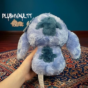 Soft blue alien plush with sparkly star eyes being held. A comforting Lilo and Stitch character gift for fans.