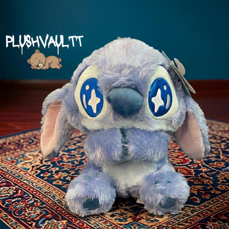 Soft blue alien plush with sparkly star eyes being held. A comforting Lilo and Stitch character gift for fans.