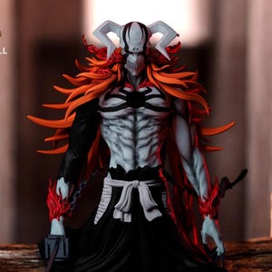 Peut inclure: Figurine détaillée d'un personnage au visage squelettique, avec des cornes blanches et des cheveux orange flamboyant. La figurine a un torse musclé et pâle avec des accents noirs et porte une robe noire. La figurine tient une épée et un objet en forme de bloc.
